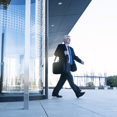 man walking out of a corporate building